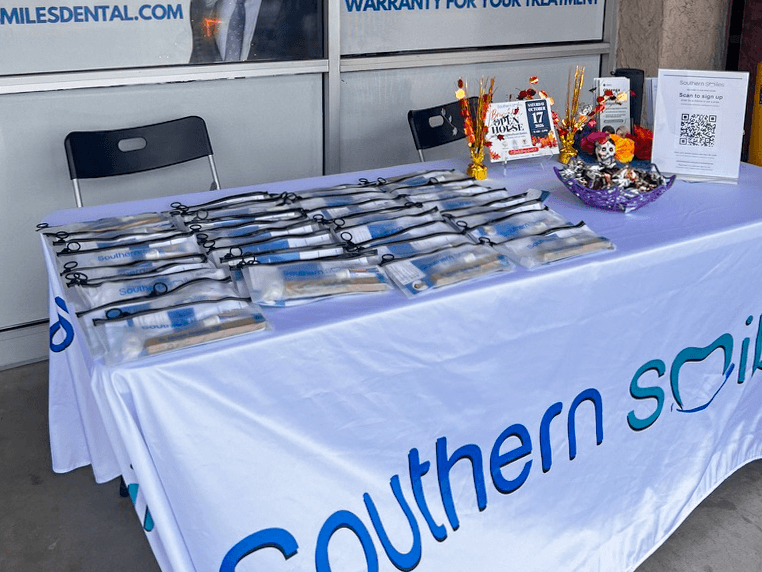 Dental-care kits, event signs, and autumn decorations on the Southern Smiles welcome table.